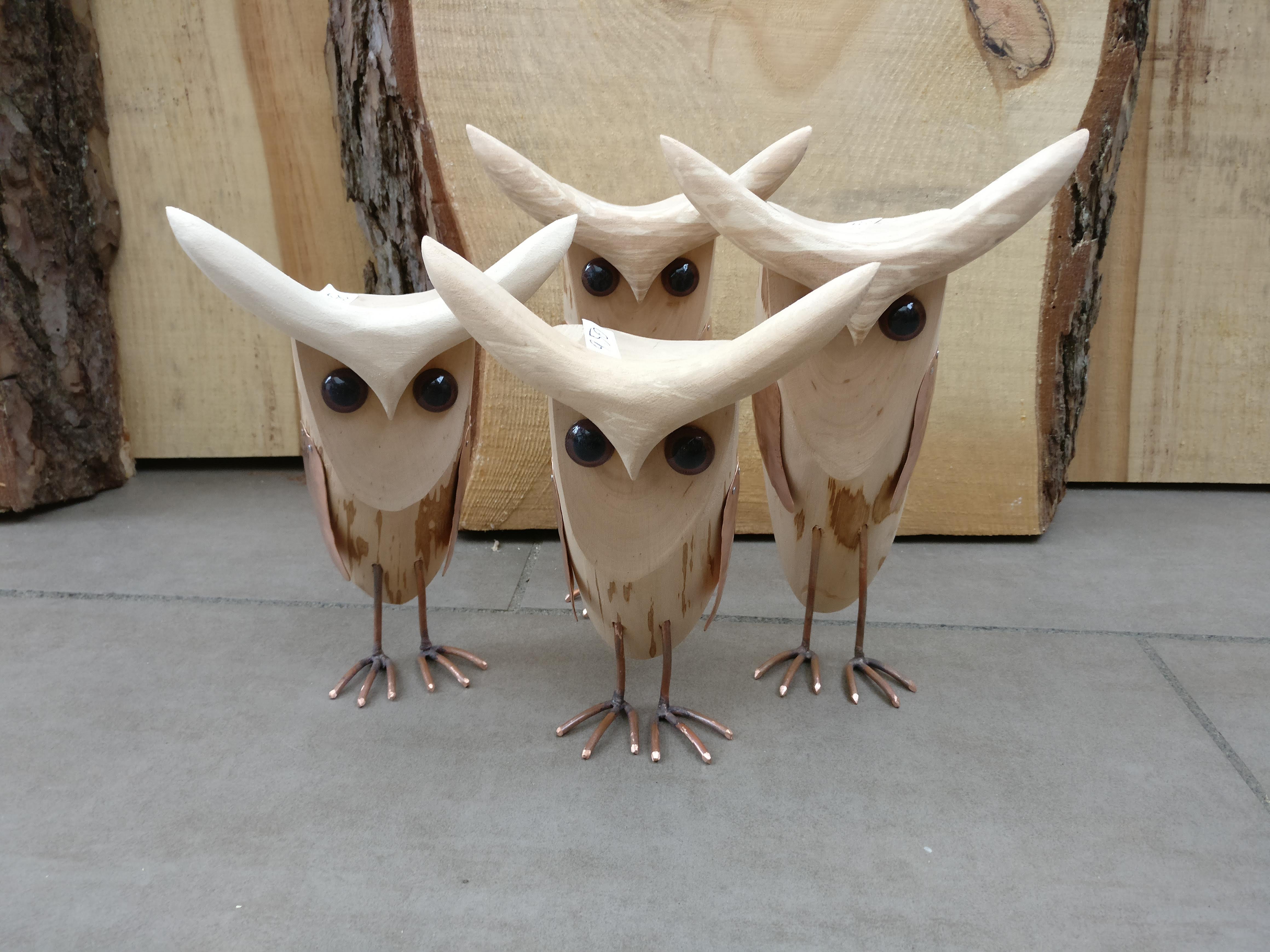 Holzeulen auf Kupferbeinen